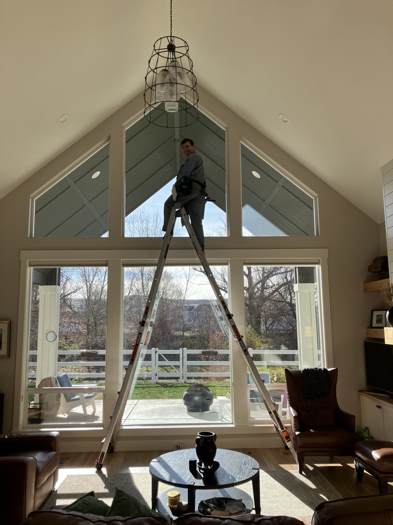 A Seymour's technician cleaning a vaulted A-frame window from inside