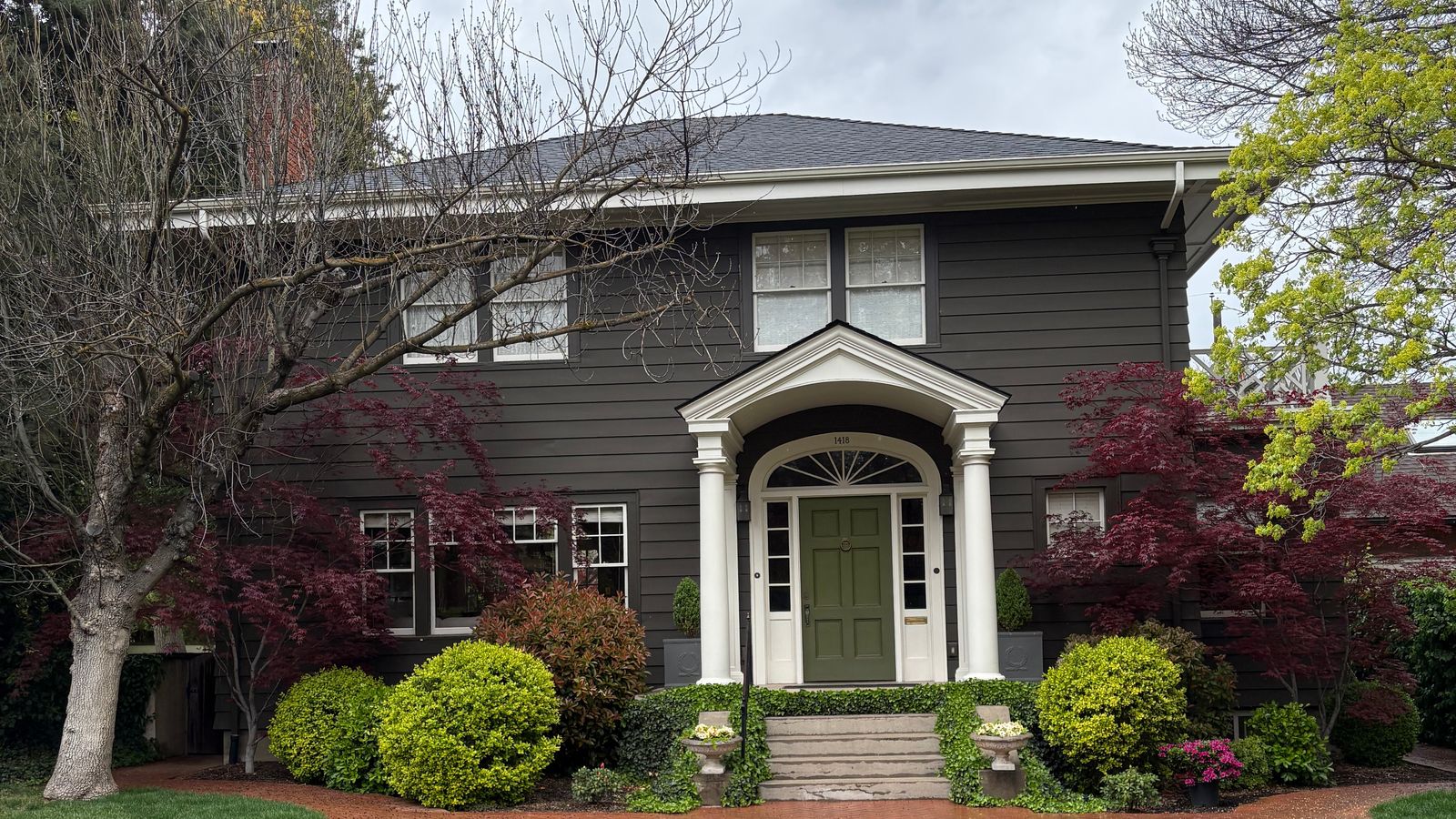 A two-story Boise home with a white columned entry and a brick front walk